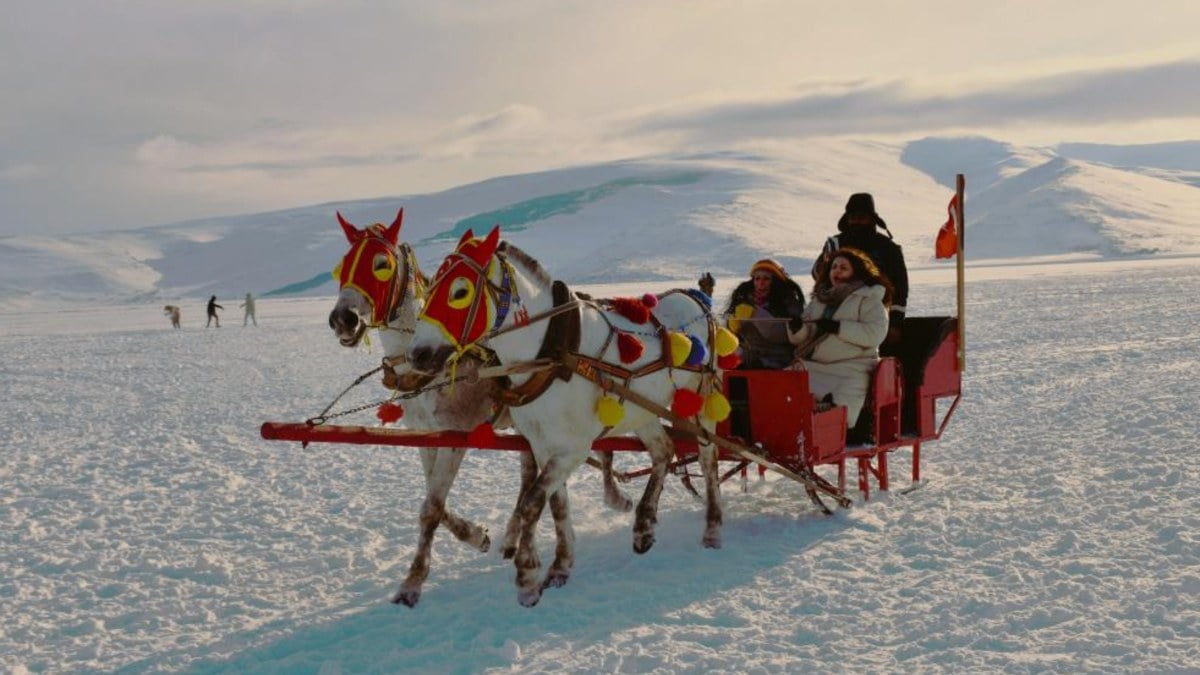 Kars’ta eğlenmeye doyamayan tatilciler gölün üzerinde atlı kızak yaptı
